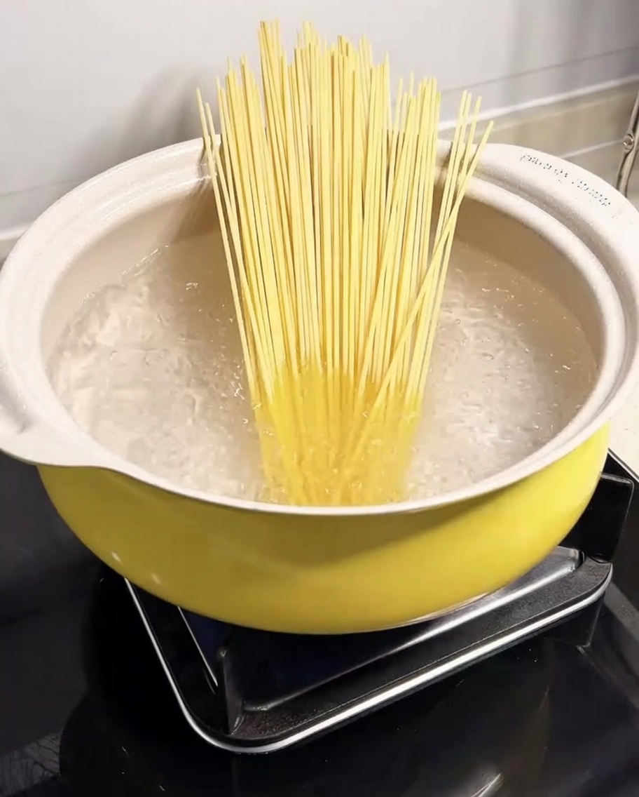 Makaron spaghetti zanurzony w garnku z gotującą się wodą.