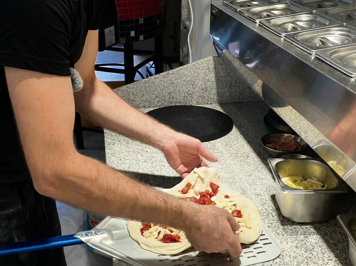 Pizza wsuwana do pieca na metalowej łopacie.