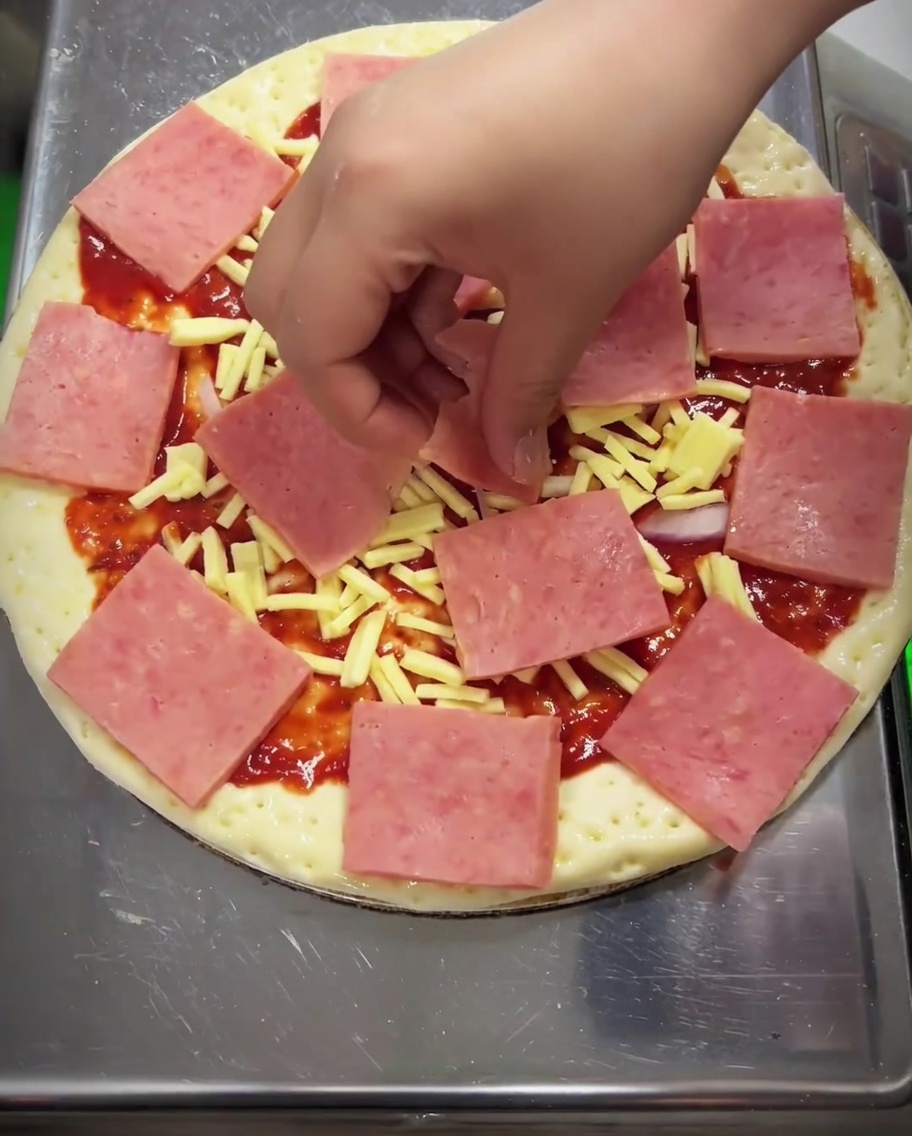 Kukurydza, plasterki pieczarek i papryka rozłożone na szynce.