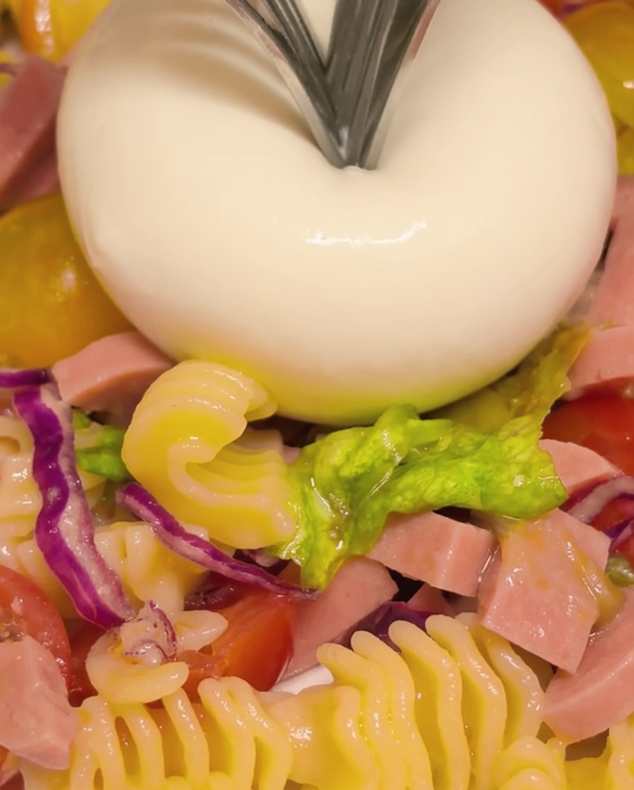 Ser burrata rozkrojony widelcem, z którego wypływa kremowe wnętrze.