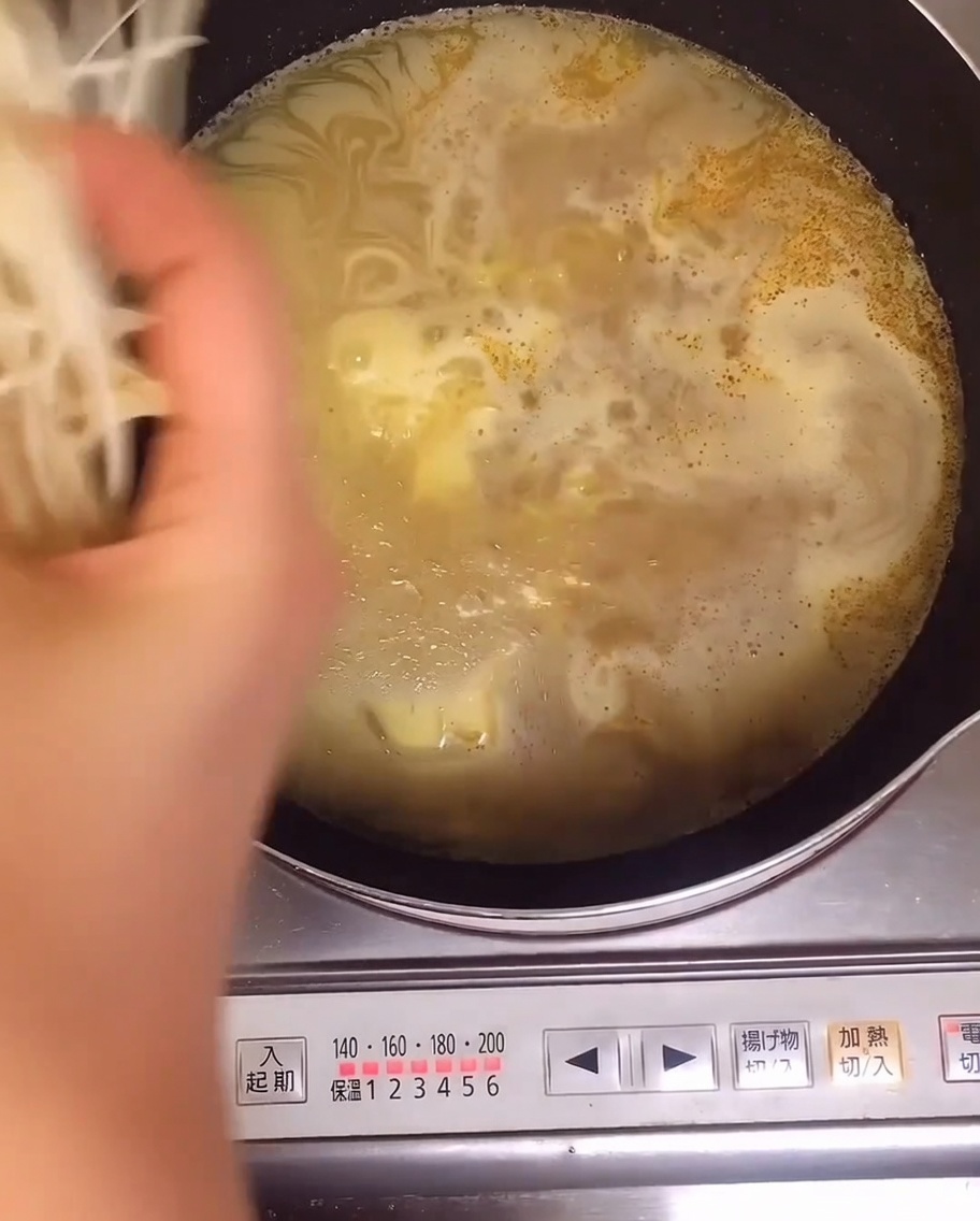 Świeże kiełki fasoli dodawane do garnka z gotującym się makaronem ramen.