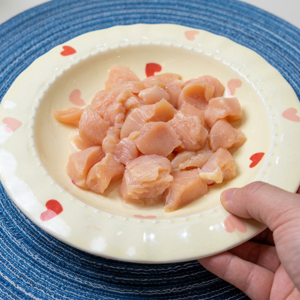 Pokrojony w kostkę surowy filet z kurczaka w misce, doprawiany sosem sojowym, winem i przyprawami.