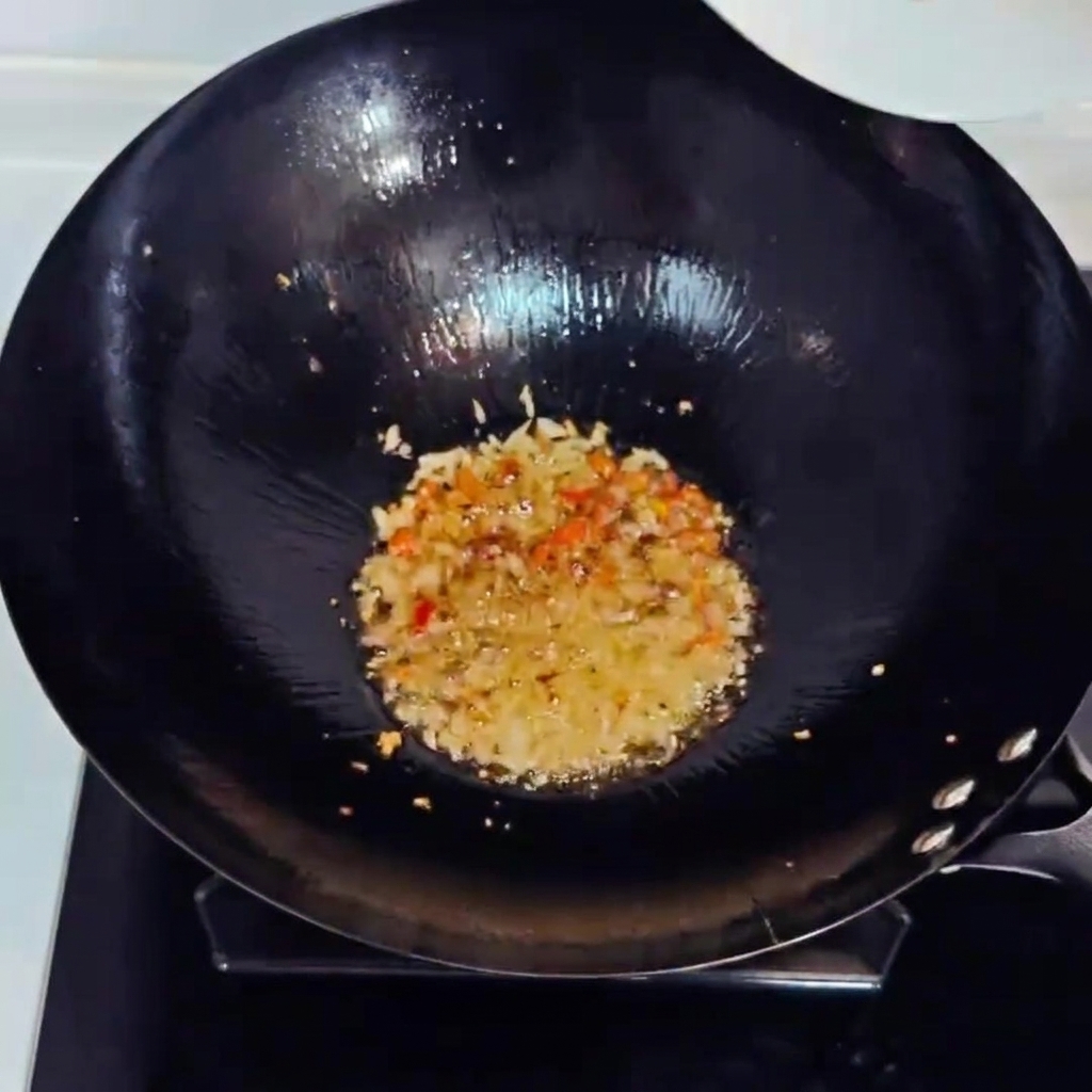 Posiekane kimchi i pokrojona w kostkę szynka smażone w woku wraz z aromatami.