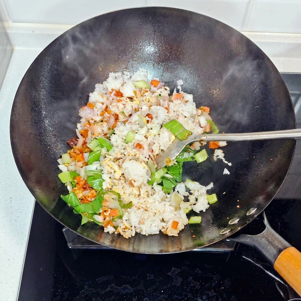 Ryż, cebula i pak choi podrzucane i smażone w woku.