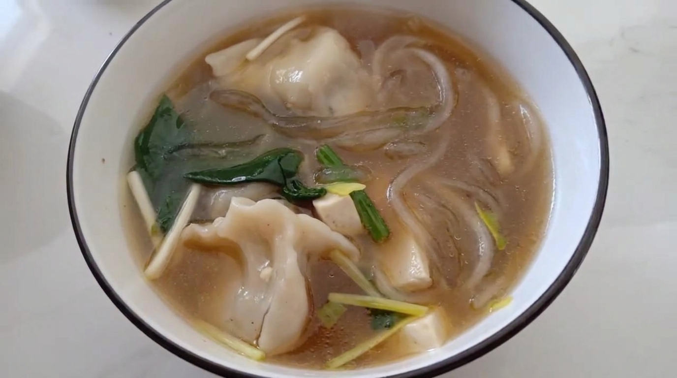 Rozgrzewająca zupa z pierożkami, makaronem vermicelli i szpinakiem