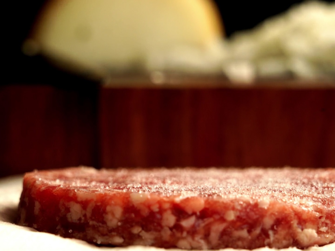 Zbliżenie na kotlet z australijskiej wołowiny Wagyu przyprawiany świeżo mielonym czarnym pieprzem.