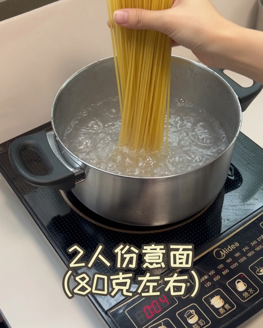 Zbliżenie na suche nitki spaghetti zanurzane w garnku z wrzącą, gotującą się wodą.