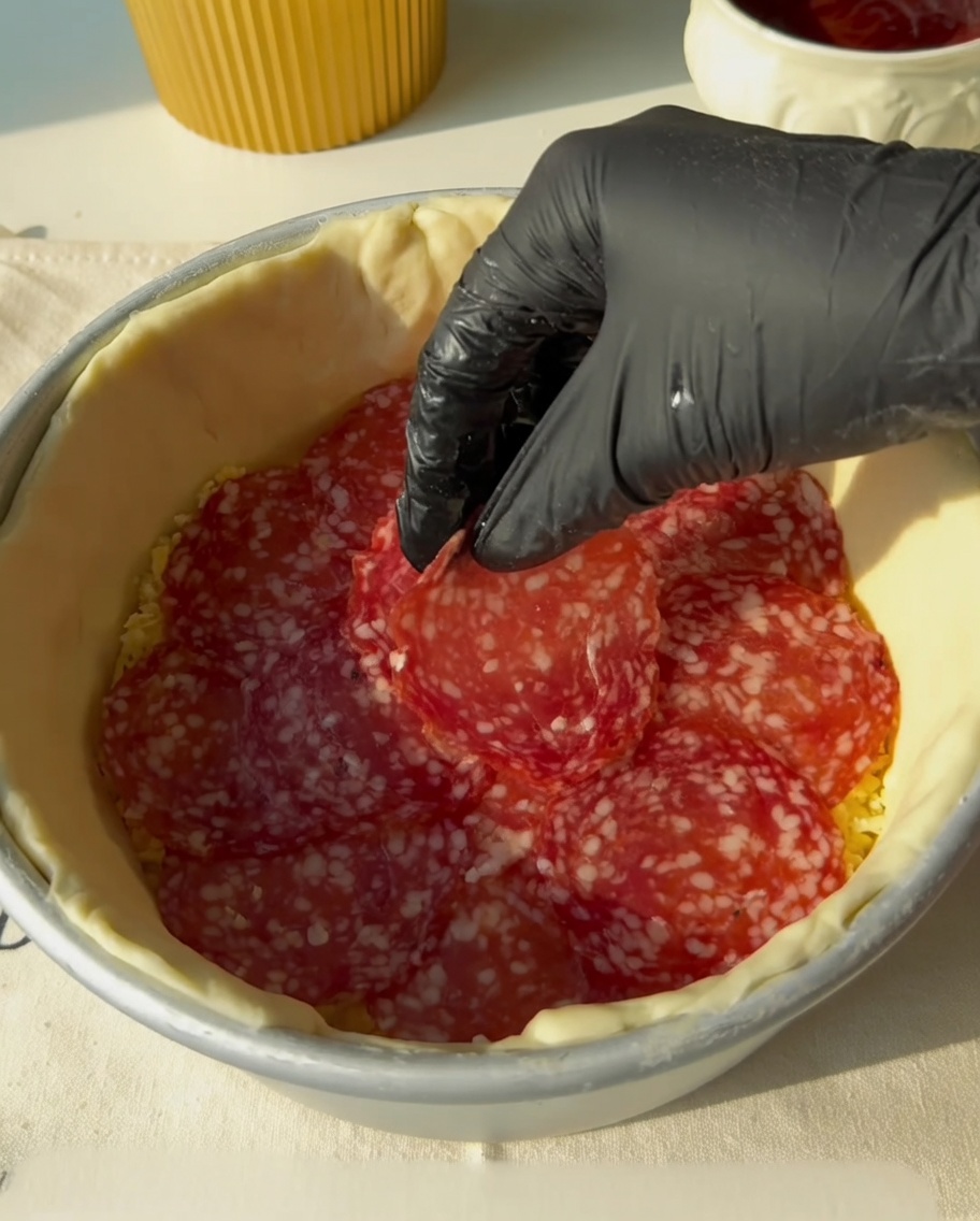 Paski boczku układane na warstwie salami.