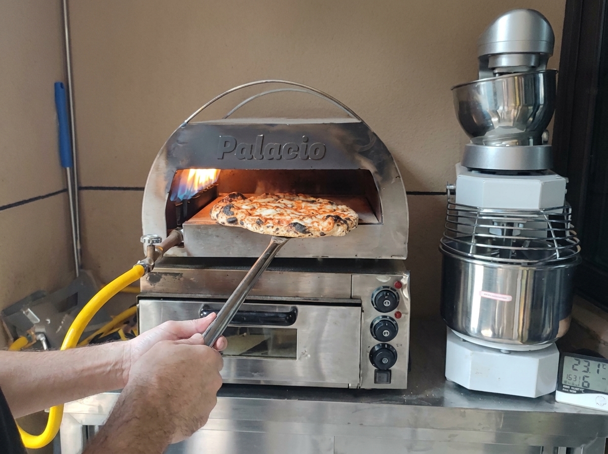 Idealnie upieczona pizza z przypieczonym brzegiem wyjmowana z pieca.