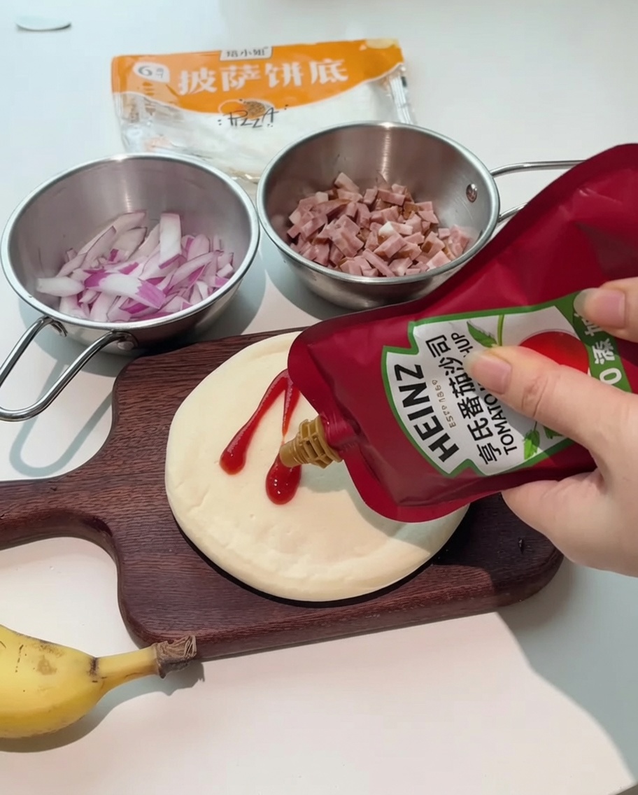 Butelki ketchupu i sosu sałatkowego wyciskane na okrągły spód do pizzy na drewnianej desce.