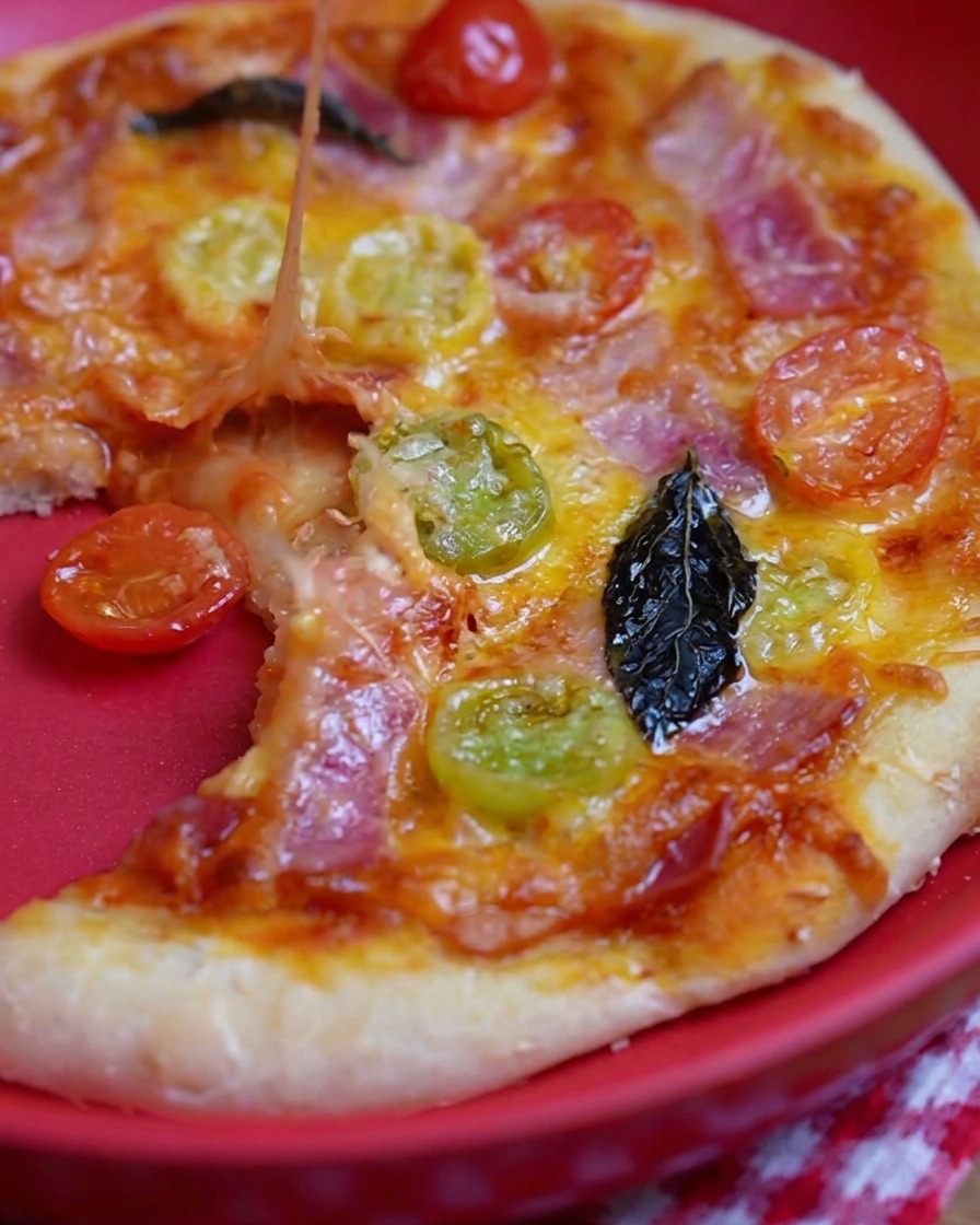 Metalowa łyżka rozprowadzająca czerwony sos na surowym spodzie pizzy.