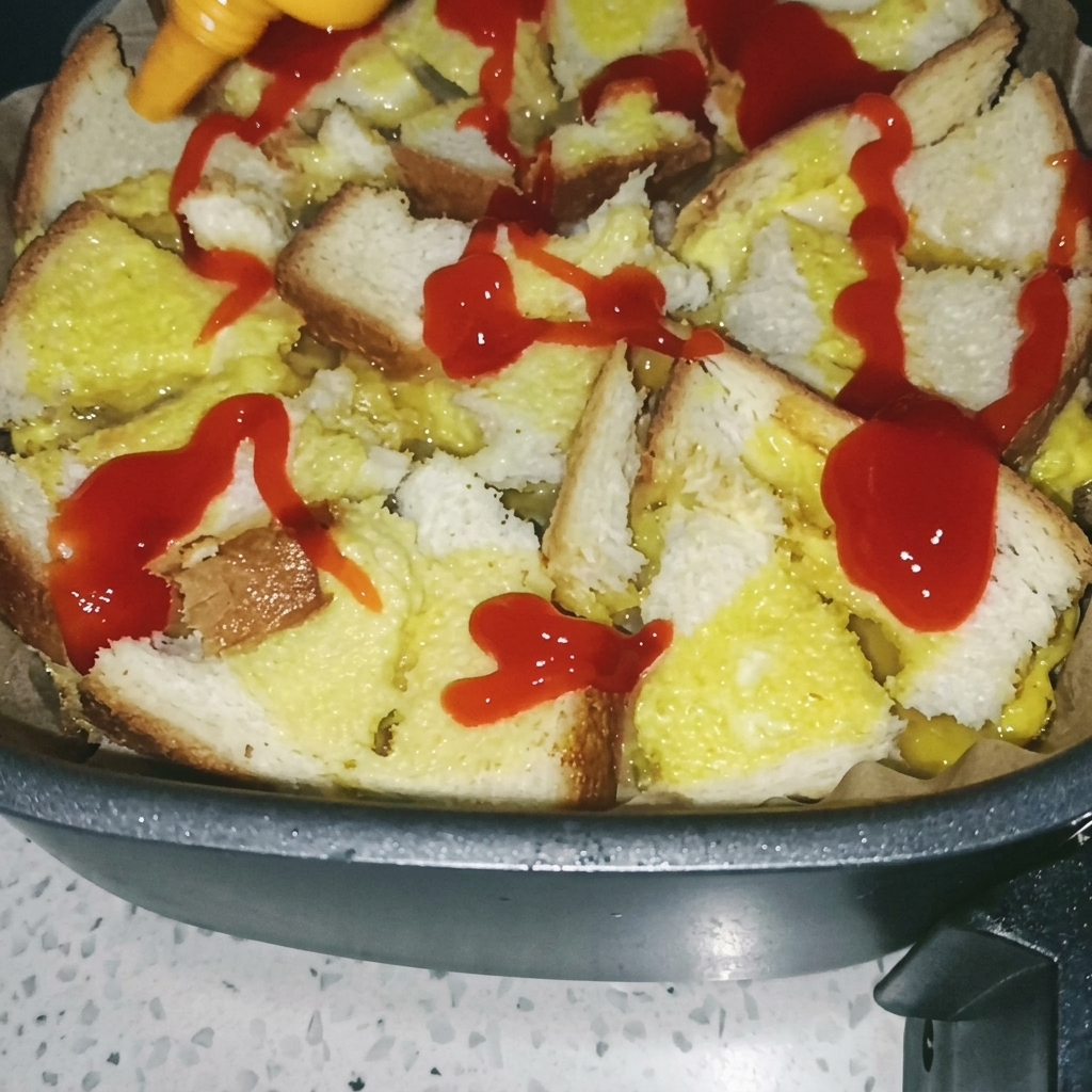 Pędzel rozprowadzający czerwony sos pomidorowy na upieczonej bazie z chleba i jajka we frytkownicy.