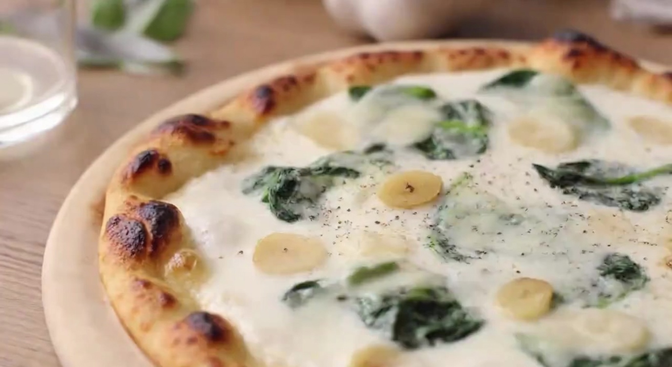 Kremowa pizza na białym sosie ze szpinakiem i czosnkiem