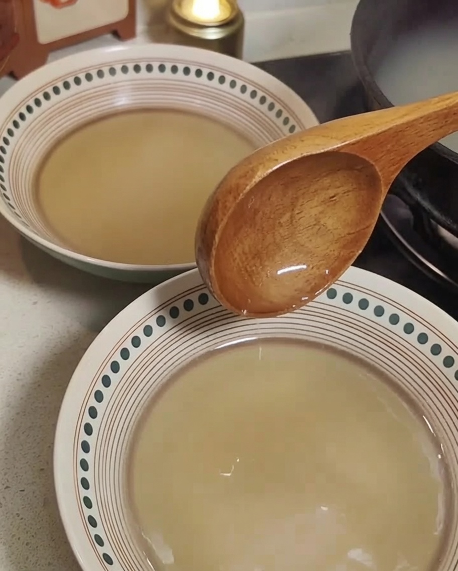 Ugotowany makaron ramen przekładany do misek z przygotowanym bulionem.