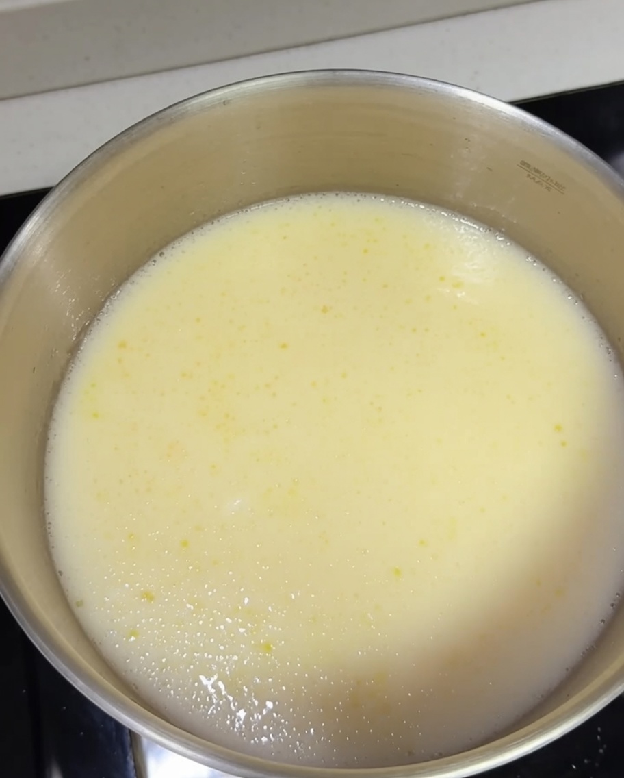Ugotowany makaron ramen dodawany do garnka z wrzącym bulionem.
