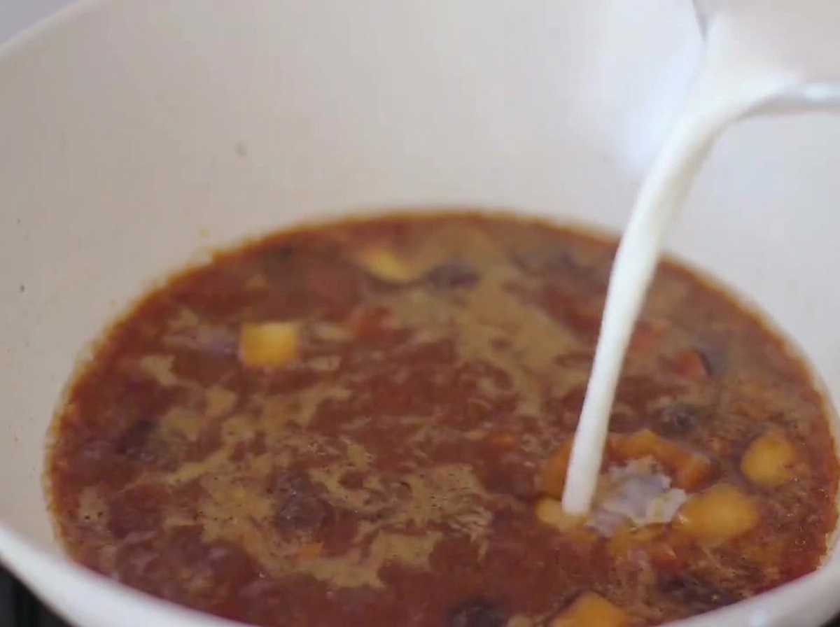 Mleko dolewane do bulionu na bazie miso na patelni.