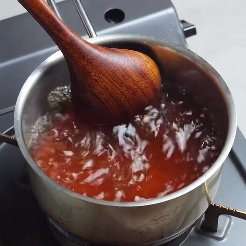 Przyprawiony bulion ramen gotujący się w rondlu podczas mieszania.
