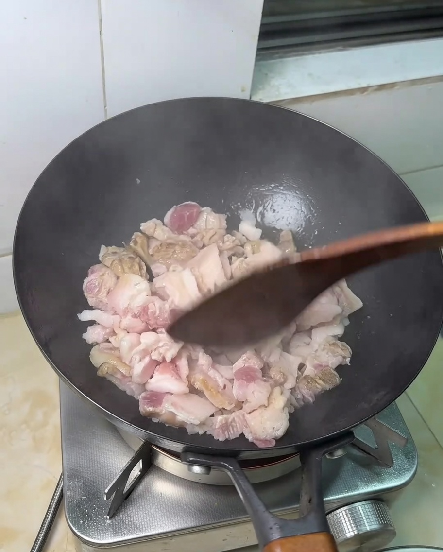 Cienkie plastry boczku smażące się na gorącej patelni.