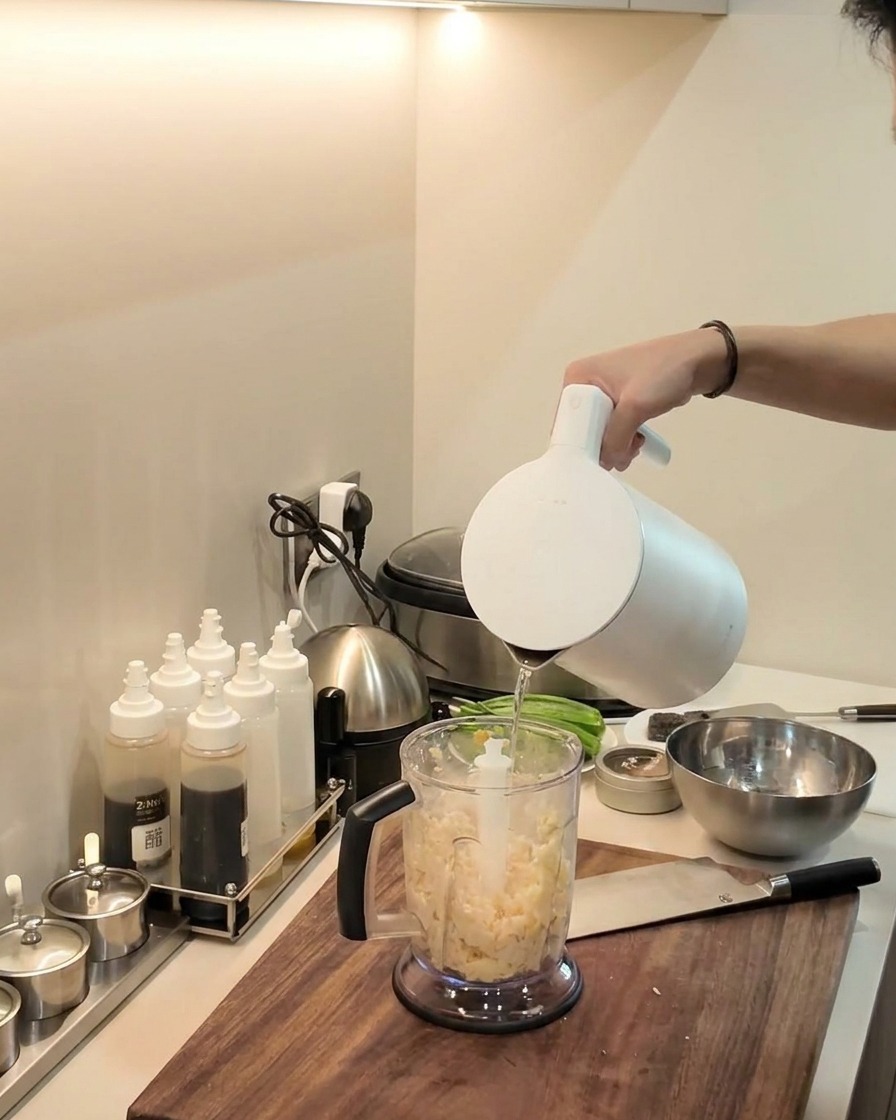 Blender ręczny miksujący masę z manioku i plantana wewnątrz dzbanka blendera.