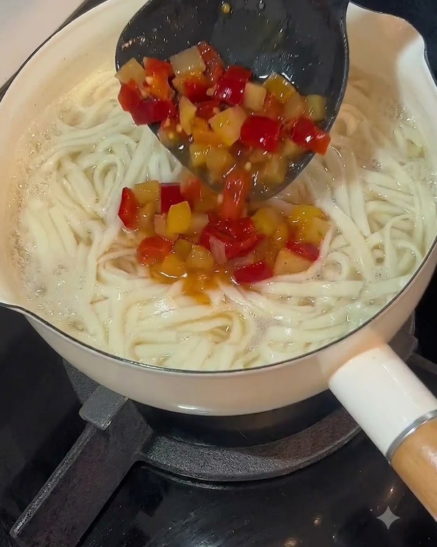 Chochla nalewająca kwaśny bulion z chili na garnek ugotowanego makaronu.