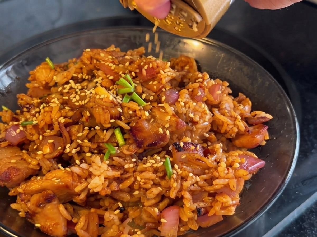 Kimchi dodawane do patelni i smażone razem z kurczakiem oraz cebulą.