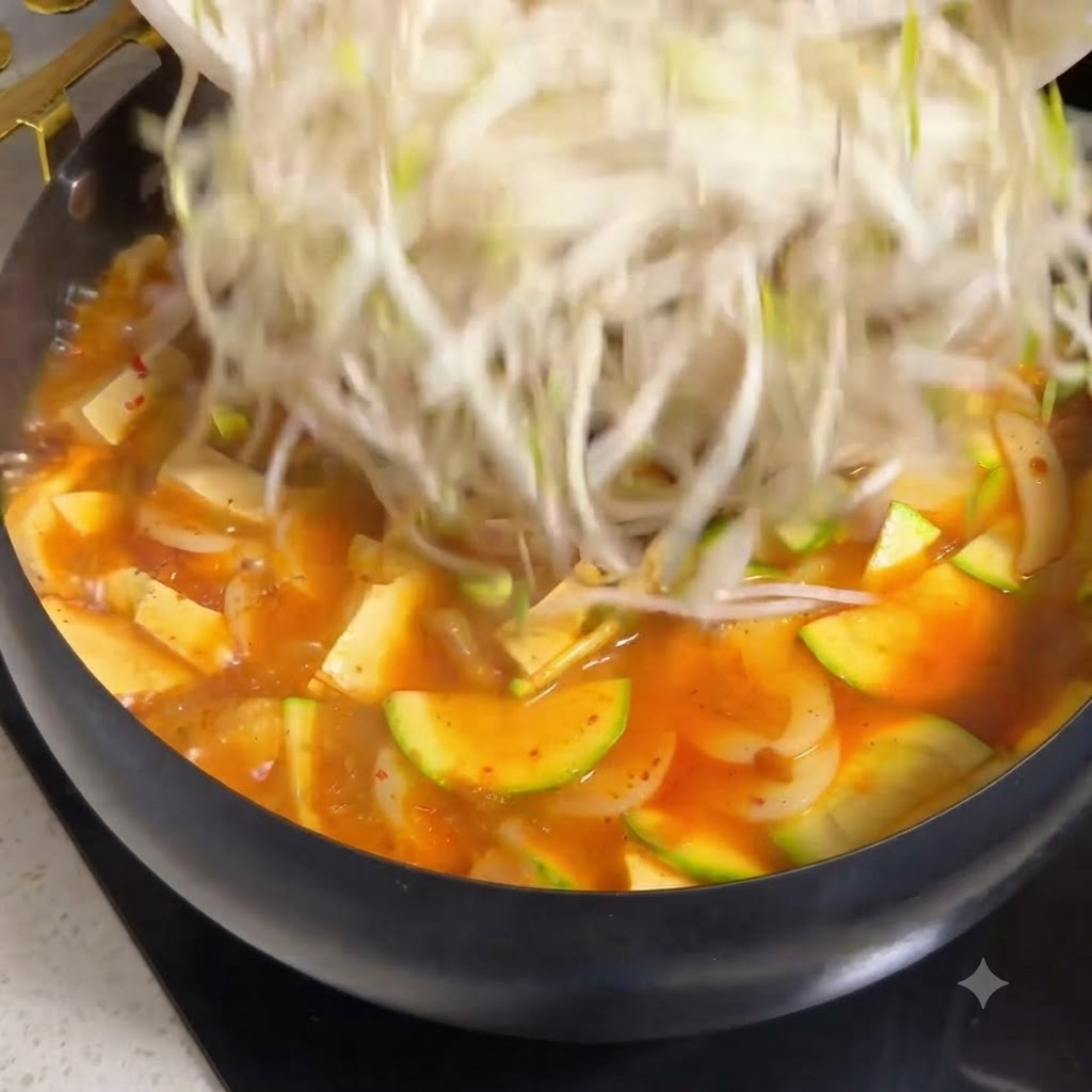 Starty ser mozzarella posypywany wokół gulaszu wołowo-pomidorowego wokół kopuły ryżowej.