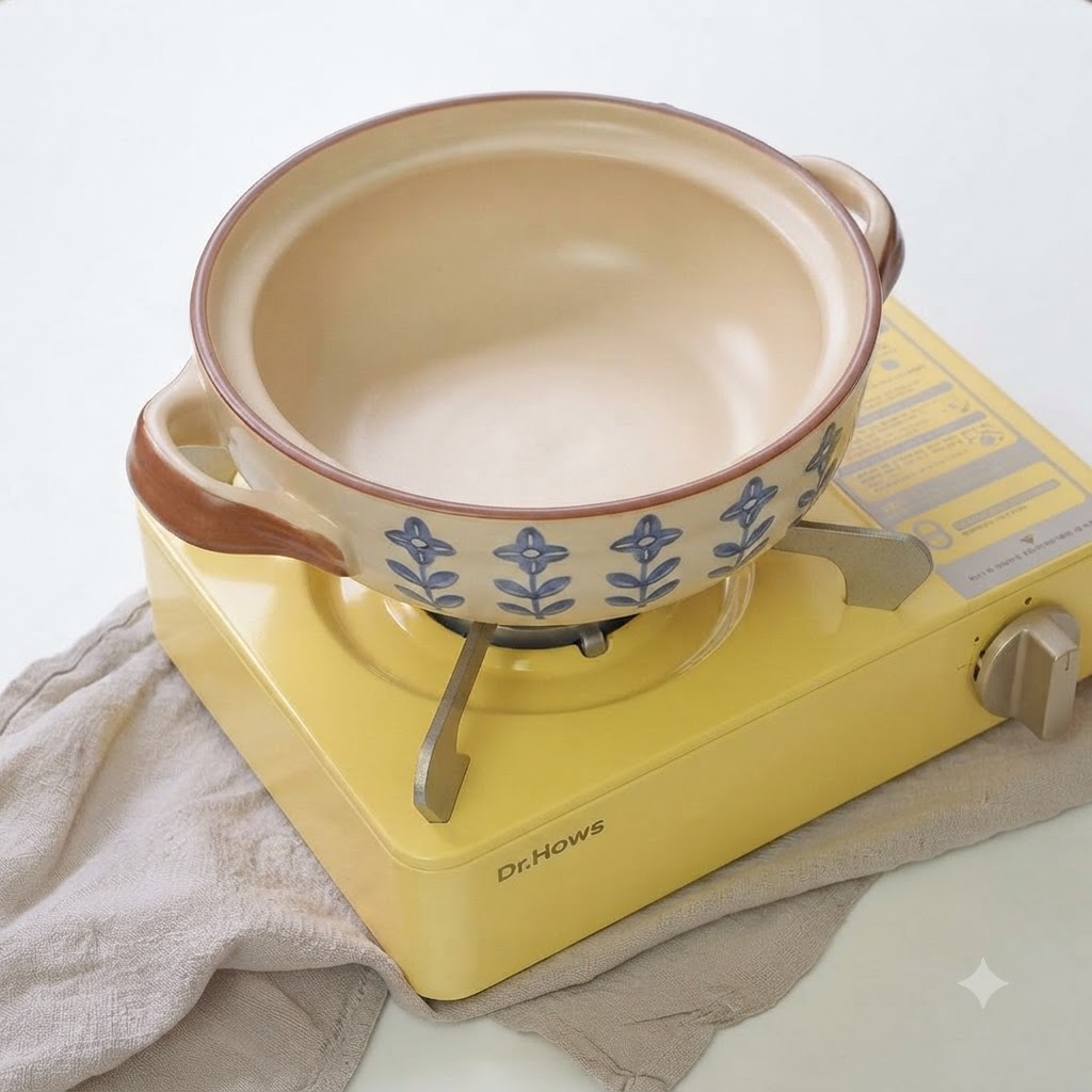 Zielona cebulka i pokrojony czosnek skwierczące na oleju w ceramicznym garnku.