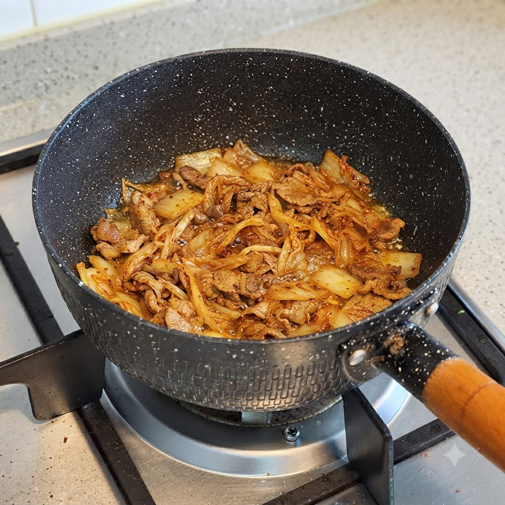 Woda wlewana do garnka zawierającego ugotowane kimchi i wołowinę.
