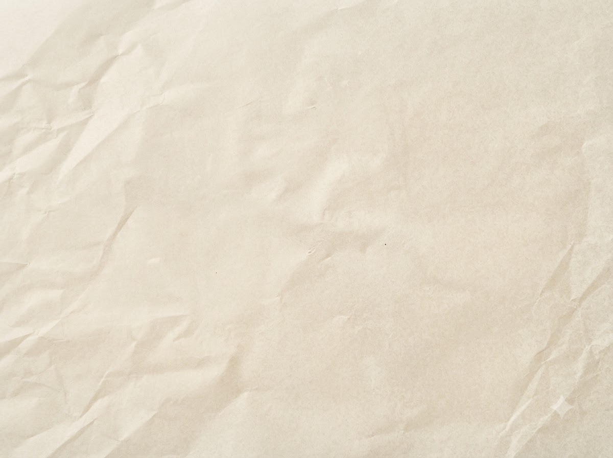 Uformowane surowe kotlety mięsne spoczywające na arkuszu papieru do pieczenia.