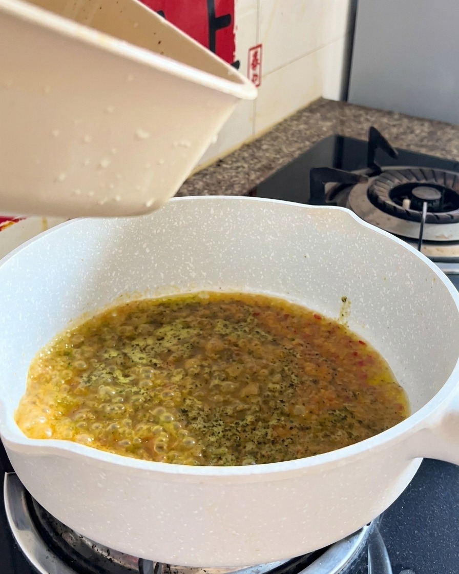 Ugotowane spaghetti i płyn łączone na patelni podczas końcowego mieszania.
