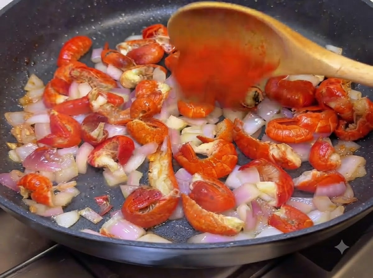 Chili w proszku i koreański sos mieszane na patelni za pomocą drewnianej łyżki.