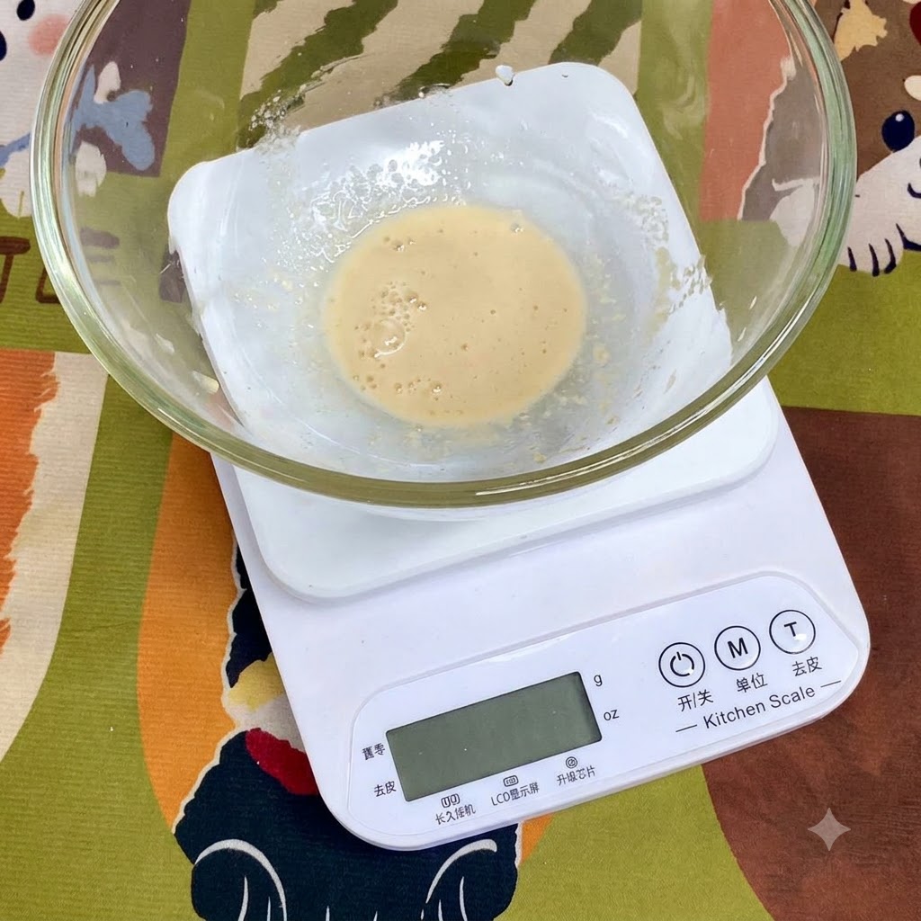 Składniki takie jak mąka pszenna, sól i oliwa z oliwek odmierzone w szklanej misce stojącej na cyfrowej wadze kuchennej.