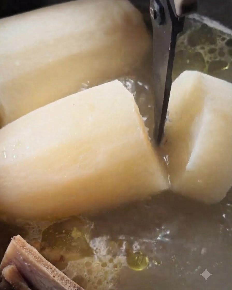 Küchenschere schneidet durch ein großes, weiches Stück weißen Rettichs in einem köchelnden Topf Rindersuppe.