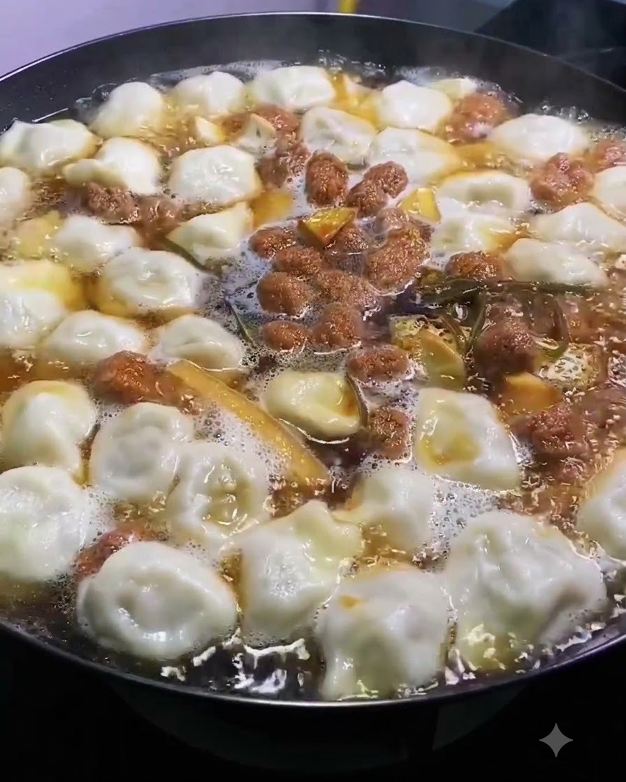 Sól posypywana równomiernie po wierzchu bulgoczącego garnka z zupą i pierożkami.