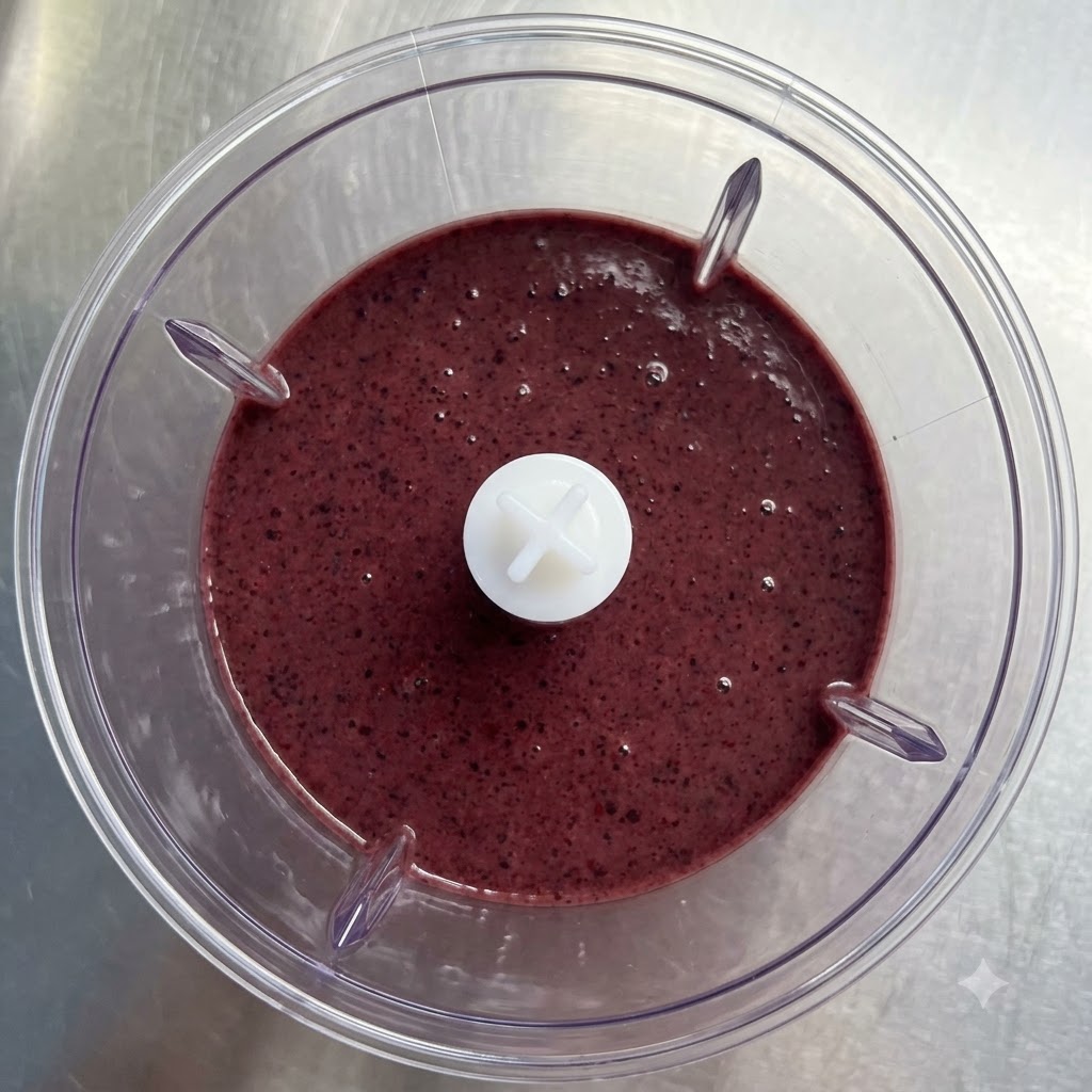 Przezroczysta szklanka napełniana gęstym, fioletowym smoothie.