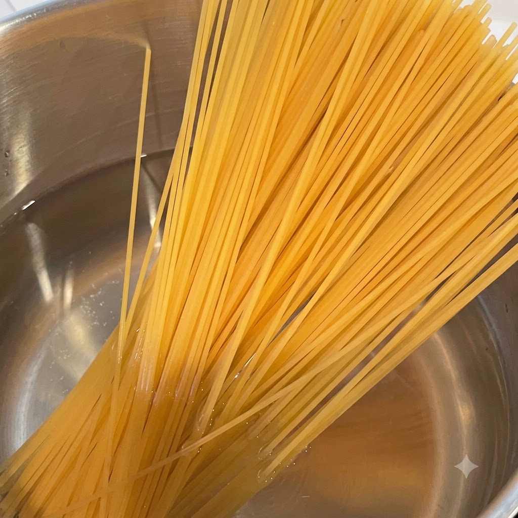 Pęczek suchego makaronu spaghetti zawieszony nad garnkiem z parującą, wrzącą wodą.