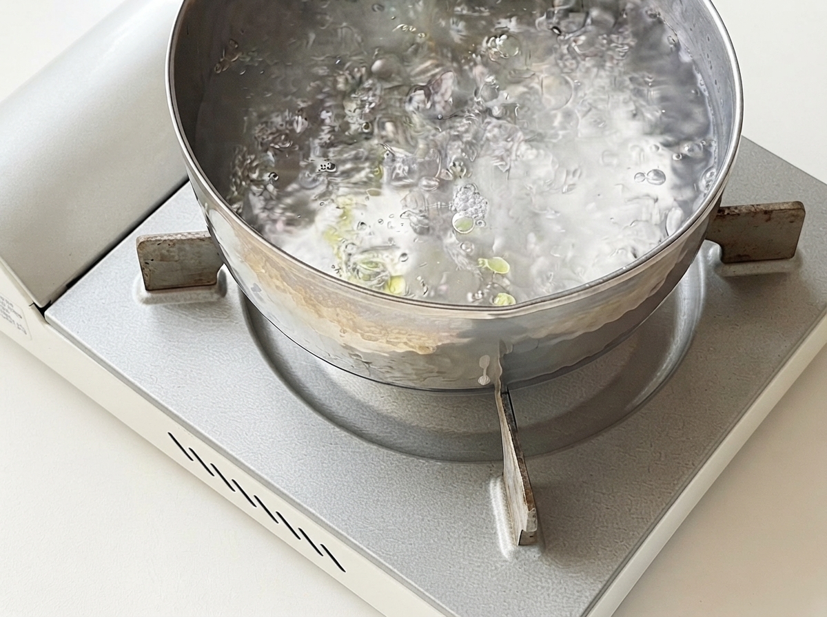 Spaghetti gotujące się w garnku z wrzącą wodą.