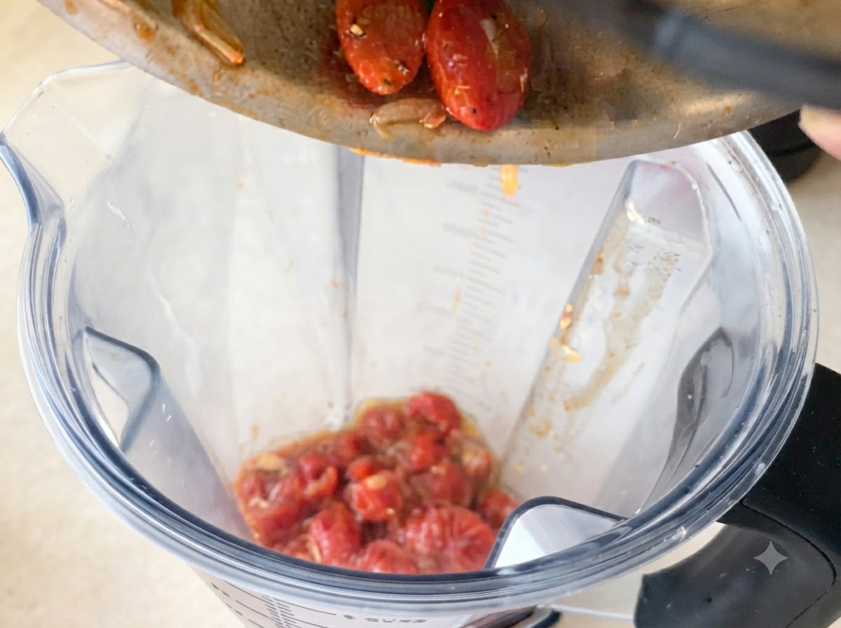 Bogaty czerwony sos pomidorowy wlewany z miski na patelnię zawierającą podsmażony czosnek i chilli.