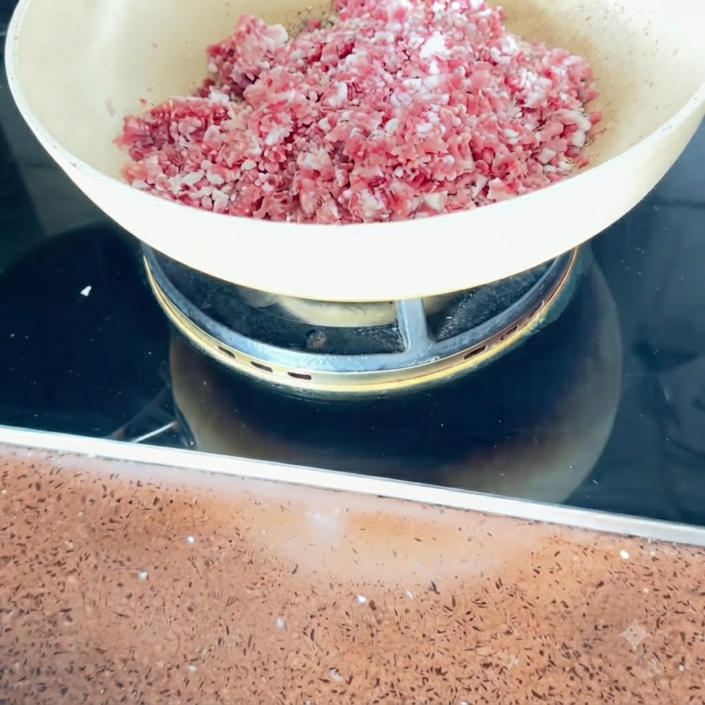 Kostki boczku wieprzowego smażące się na patelni na średnim ogniu.