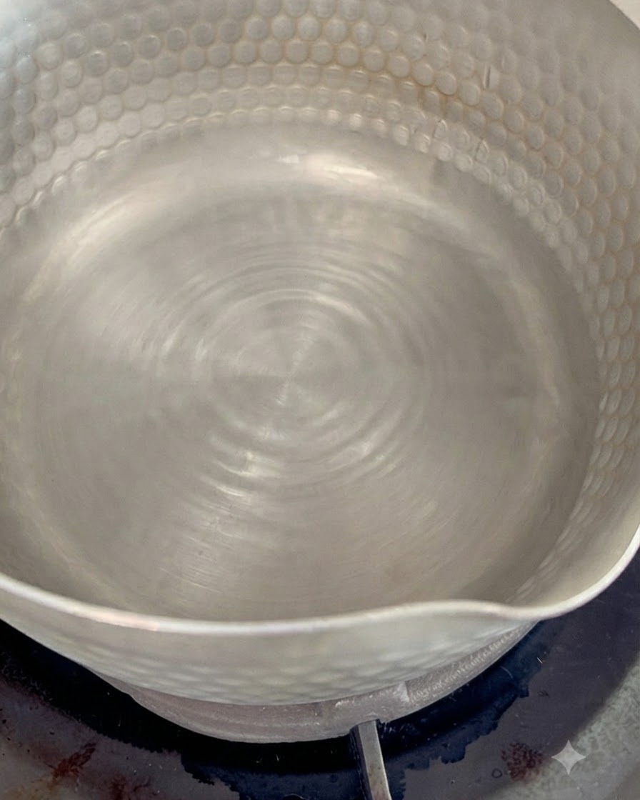 Suszone płatki bonito gotujące się w małym garnku z wodą na aromatyczny bulion dashi.