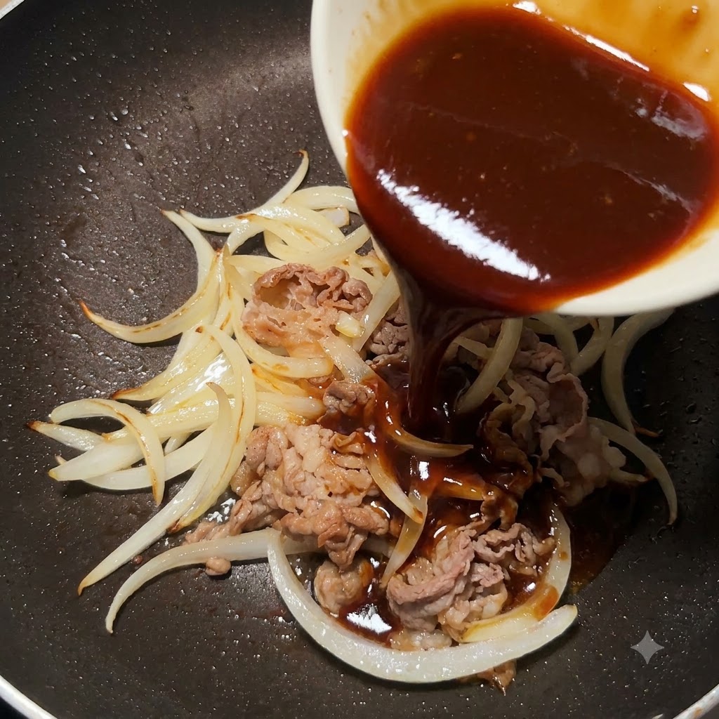 Gęsty sos teriyaki wlewany z małej białej miski na patelnię z usmażoną wołowiną i cebulą.