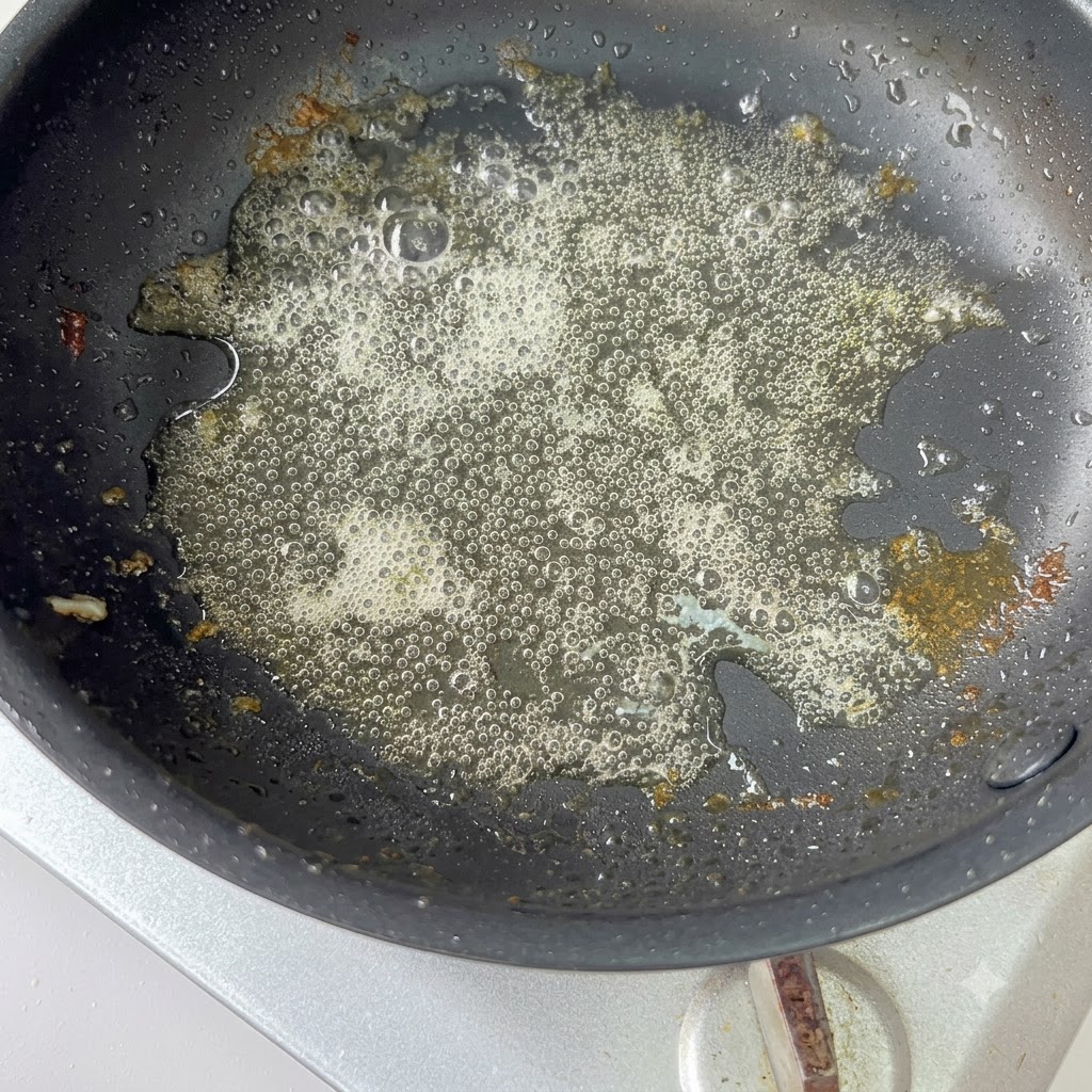 Pokrojona czerwona cebula smażona na gorącej patelni z resztą oleju.