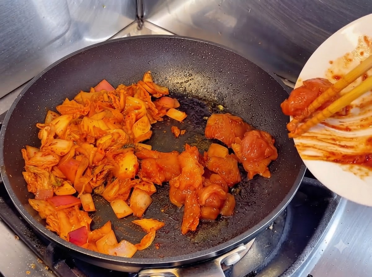 Używanie pałeczek do zsunięcia zamarynowanych kawałków surowego kurczaka z białego talerza na patelnię obok podsmażonego kimchi i cebuli.