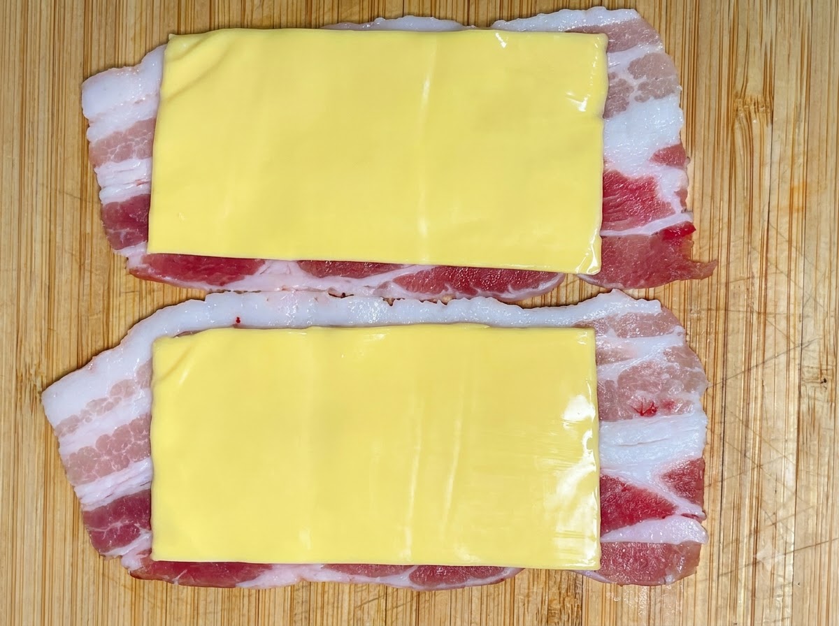 Porcja pasty krewetkowej wyciskana z rękawa cukierniczego na warstwy sera i wieprzowiny.