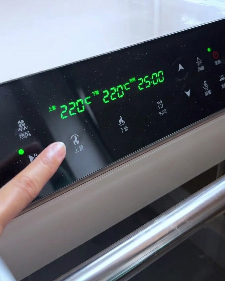 Panel sterowania piekarnika pokazujący temperaturę 220°C dla górnych i dolnych elementów grzewczych.