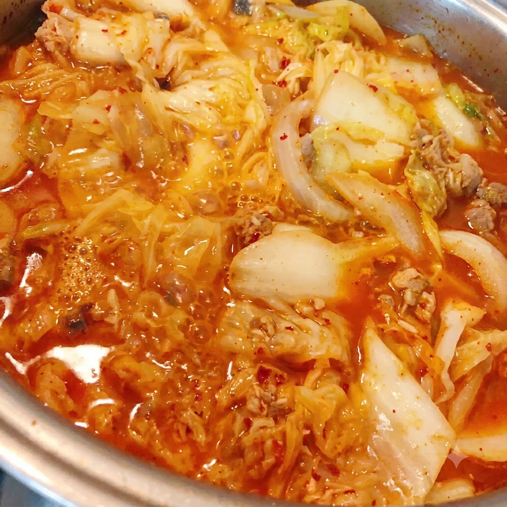 Mielone chili dodawane do gotującego się gulaszu z kimchi i tuńczyka.