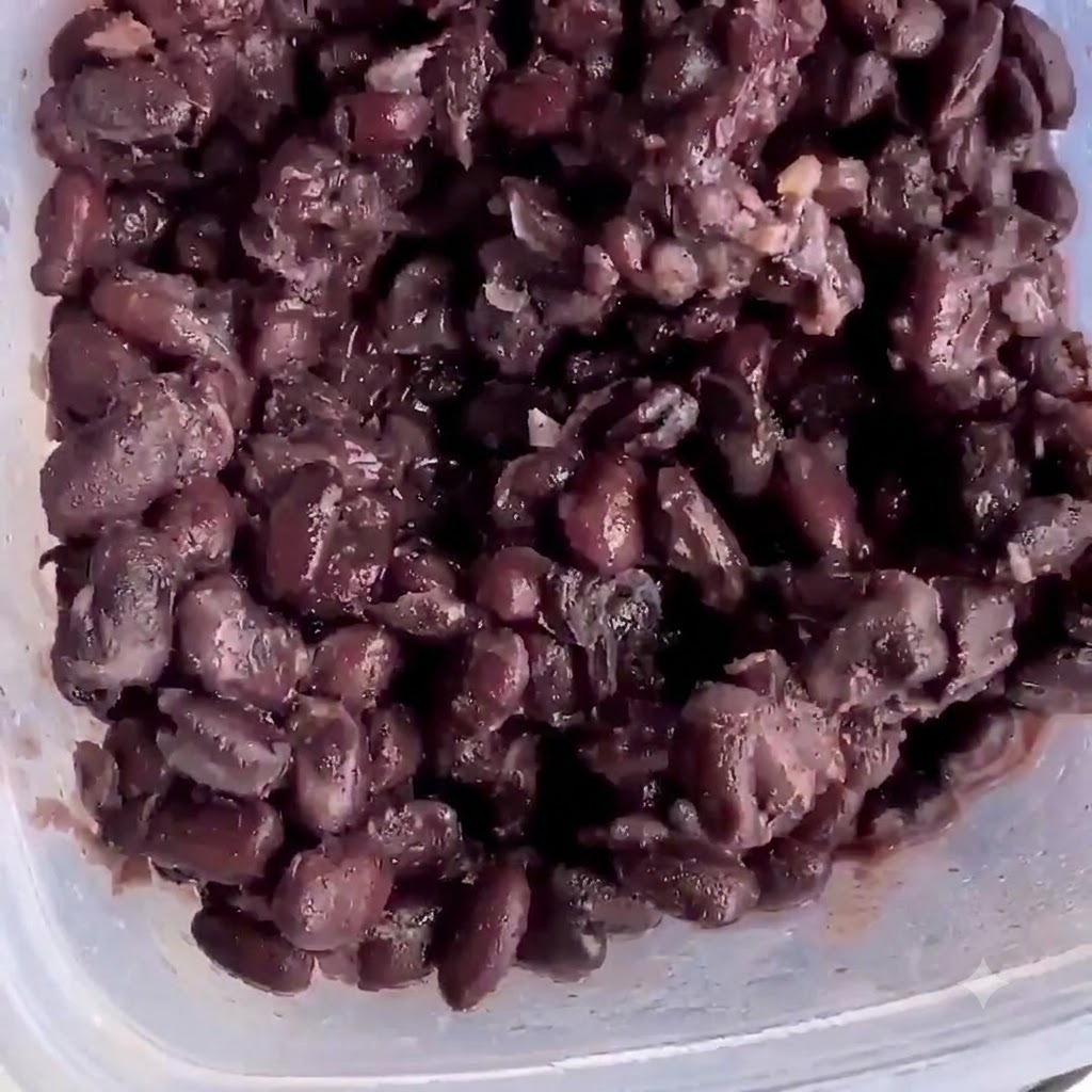 Ugotowana czarna fasola w plastikowym pojemniku gotowa do rozgniecenia.