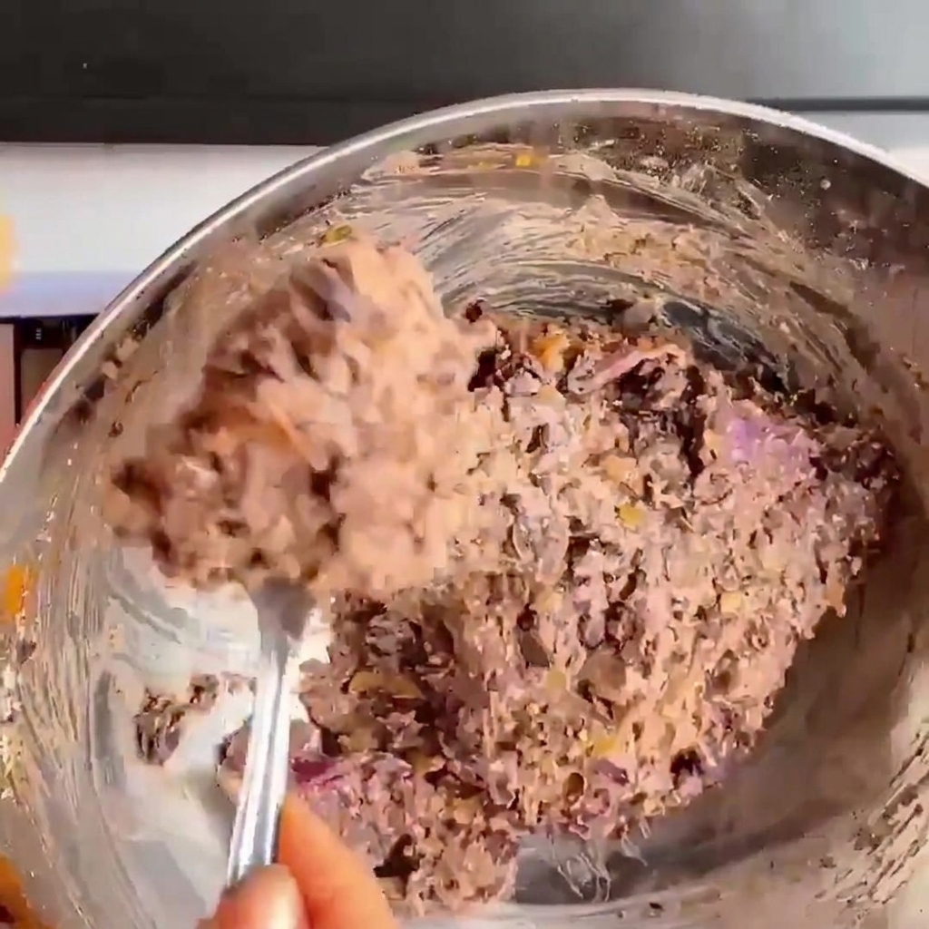Zbliżenie dłoni dociskających i formujących masę z czarnej fasoli w okrągły kotlet do burgera.