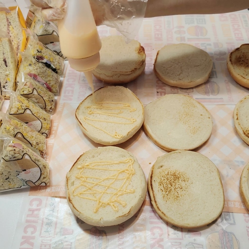 Tajny sos wyciskany zygzakiem na powierzchnię bułek do burgerów.
