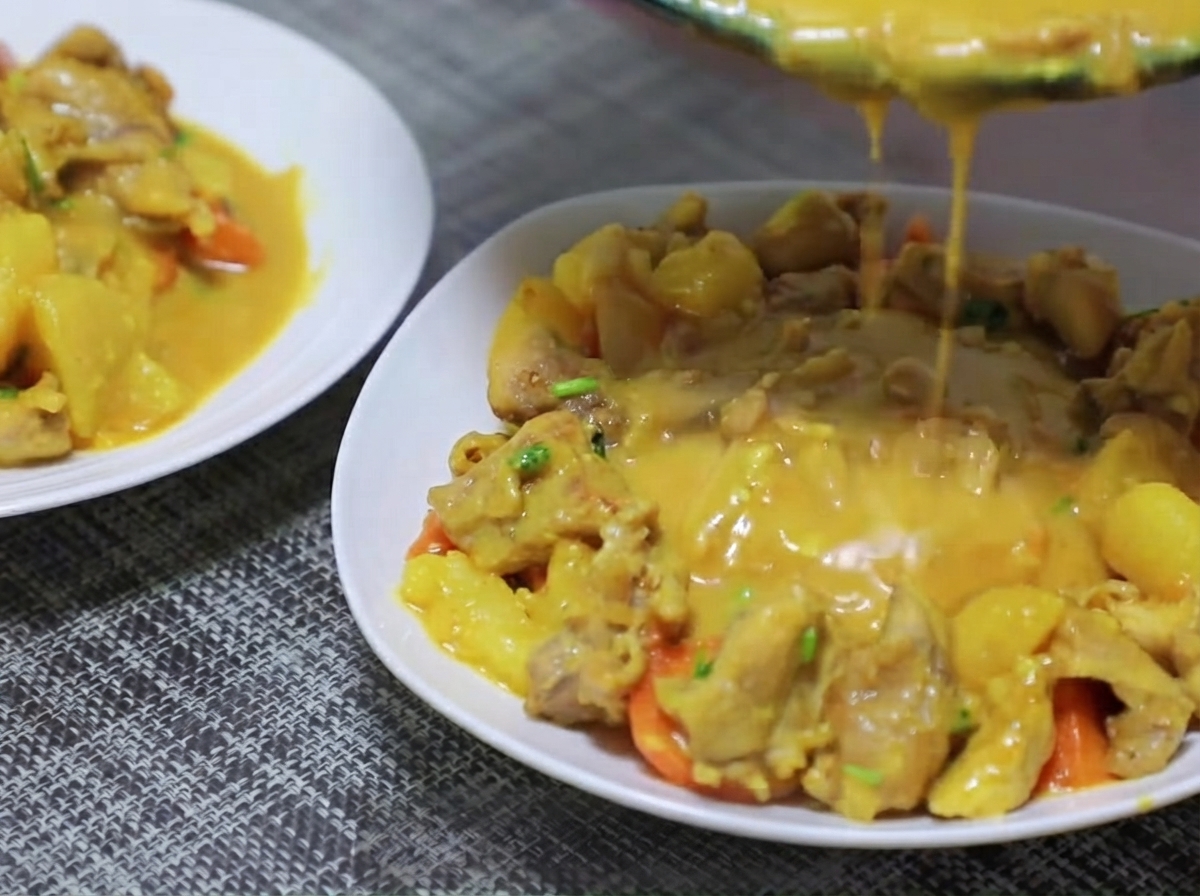 Kawałki ziemniaków i marchewki dodawane na patelnię i podsmażane z bazą curry.
